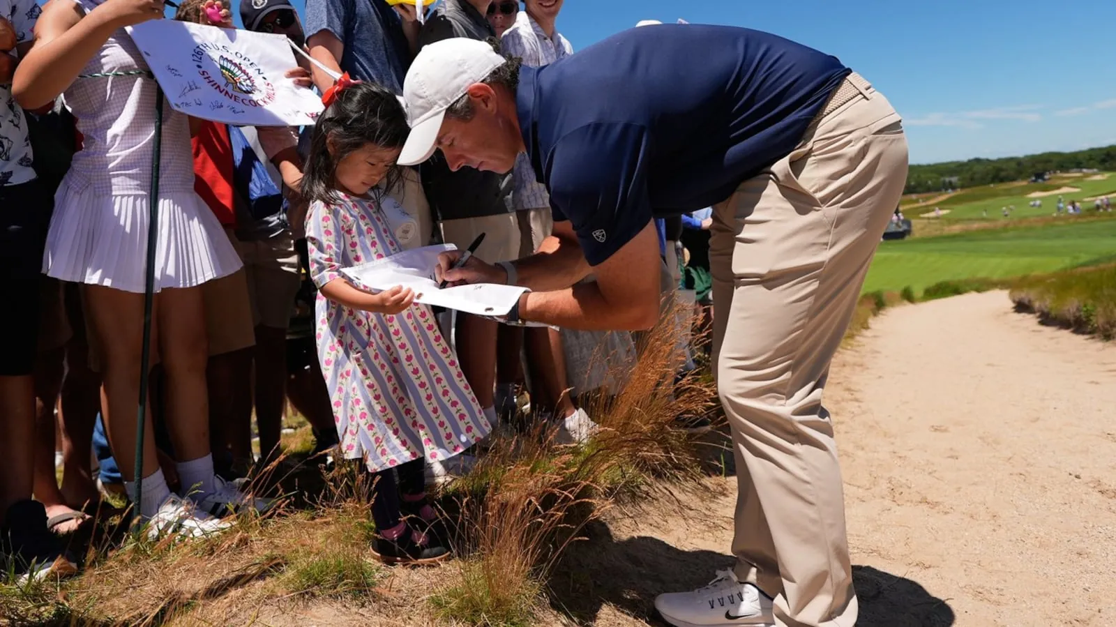 Rory McIlroy, of Northern Ireland, signs autographs during a practice round for the U.S. Open golf tournament at Shinnecock Hills Golf Club in Southampton, N.Y., Monday, June 15, 2026. (AP Photo/David J. Phillip)
