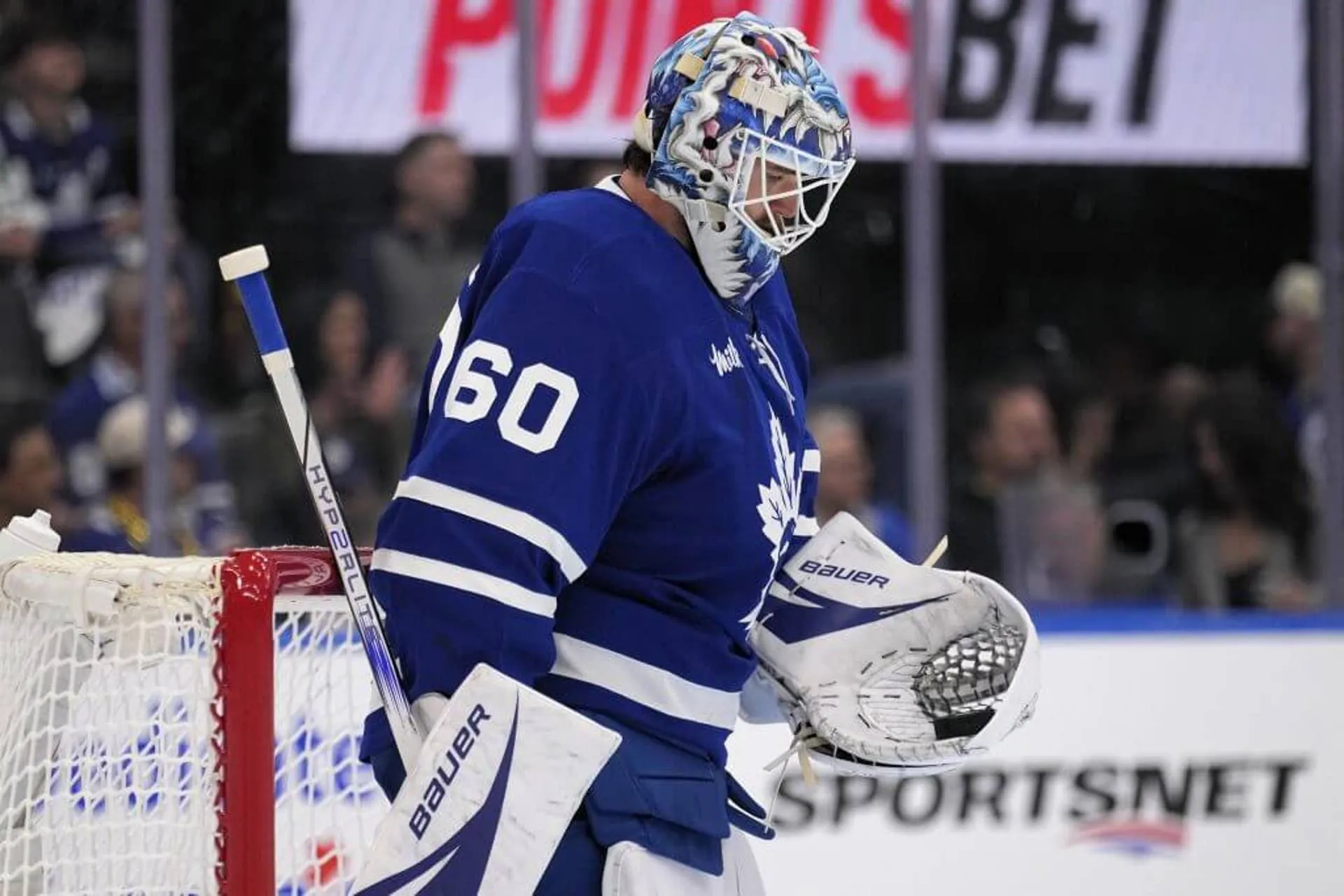 Toronto Maple Leafs goaltender Joseph Woll looks at a puck in his glove during a stoppage.